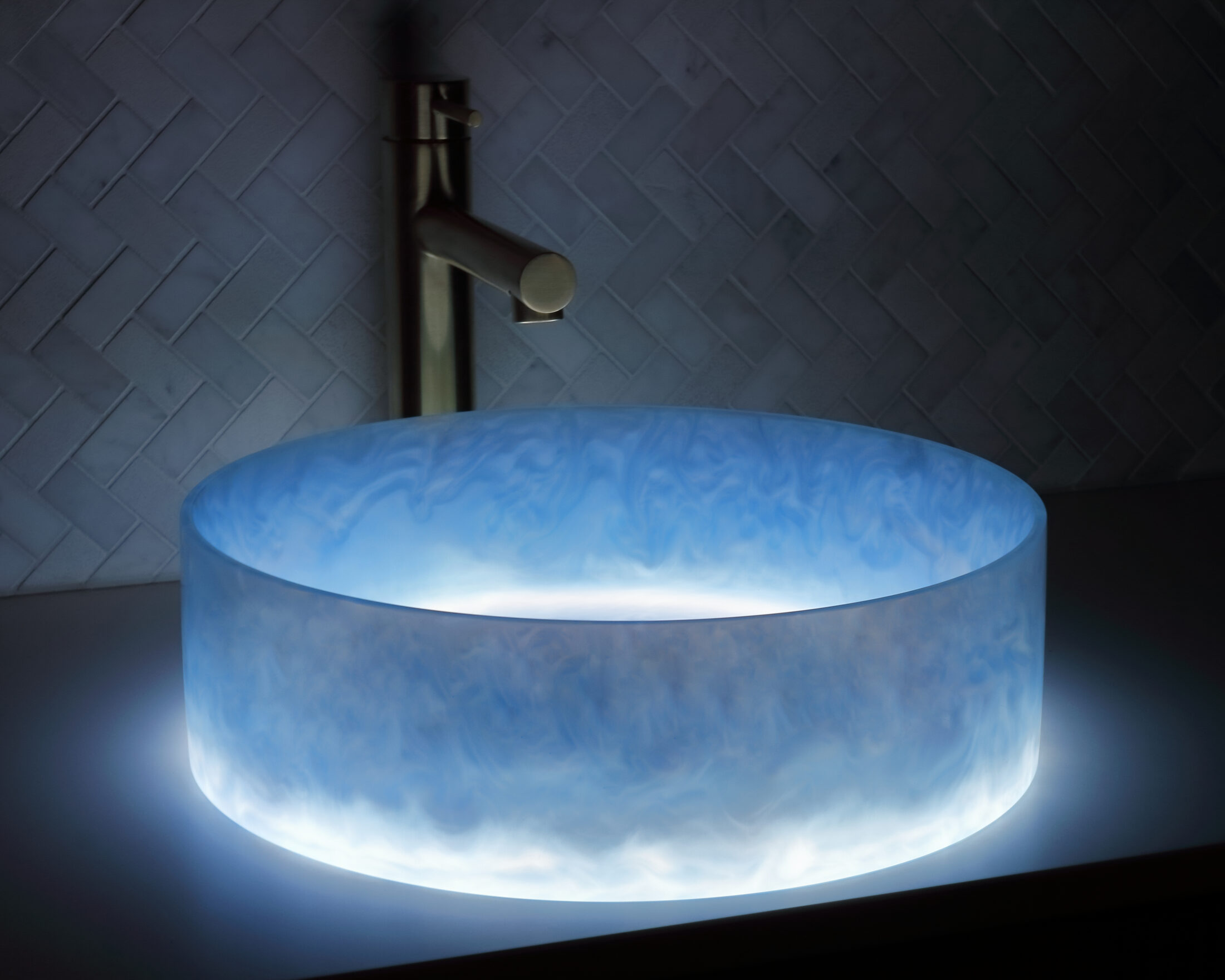 The Basin Lab's tahiti blue coloured resin basin from their akoya series illuminated by their lightbox